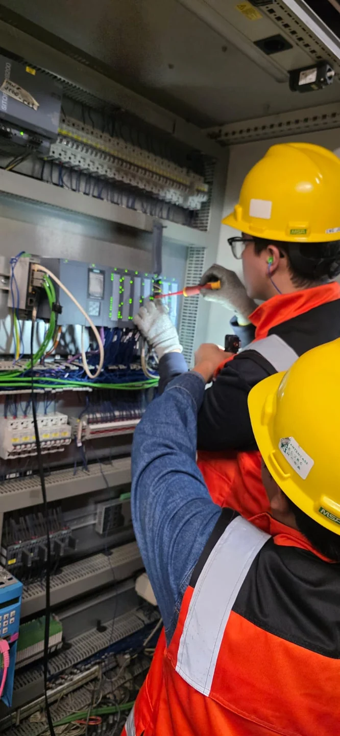 Técnicos dando soporte en gabinete eléctrico industrial